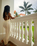 Sheer Backless Dress in cream, worn on a resort balcony